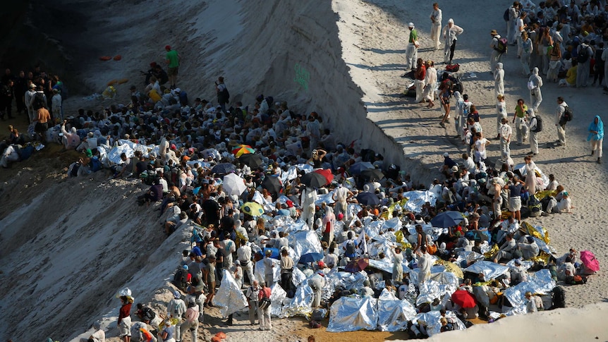 Hundreds of environmental activists sit inside a pit at a coalmine site.