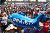 Protesters display a balloon of a fish with the words 'China Out!' written on it during a rally in Manila.