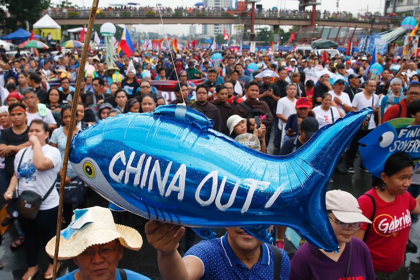 Protesters display a balloon of a fish with the words 'China Out!' written on it during a rally in Manila.