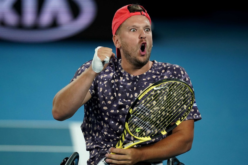 A male quad wheelchair singles player pumps his fist as he celebrates winning a point at the Australian Open.