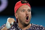 A male quad wheelchair singles player pumps his fist as he celebrates winning a point at the Australian Open.