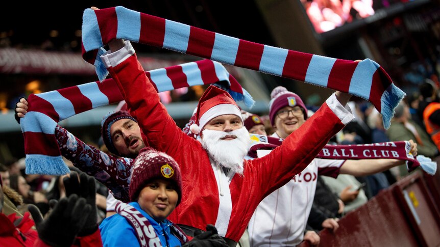 Santa holds an Aston Villa scarf
