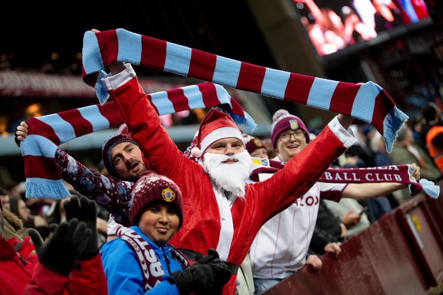 Santa holds an Aston Villa scarf