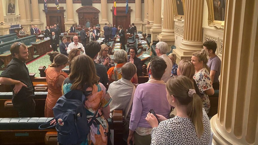 A group of people embrace in the State Parliament building.