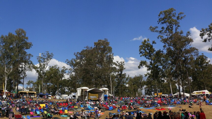 A patchwork of camp chairs and tarpaulins cover the hill in front of the Gympie Muster main stage