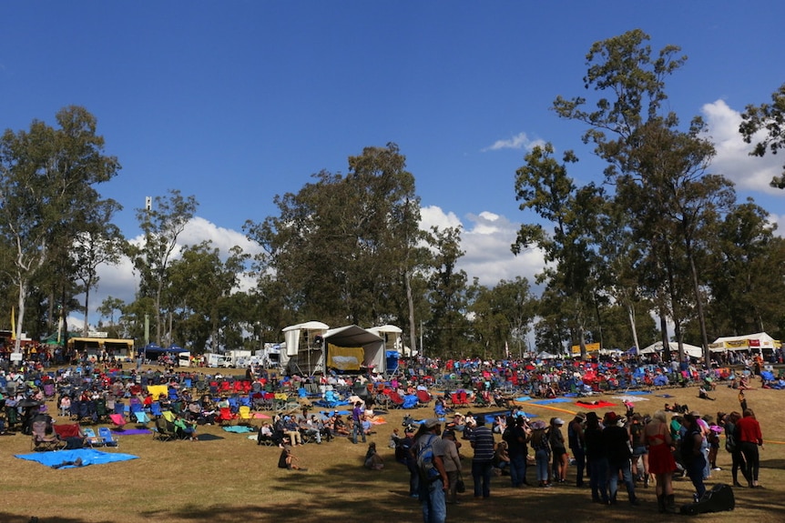 A patchwork of camp chairs and tarpaulins cover the hill in front of the Gympie Muster main stage