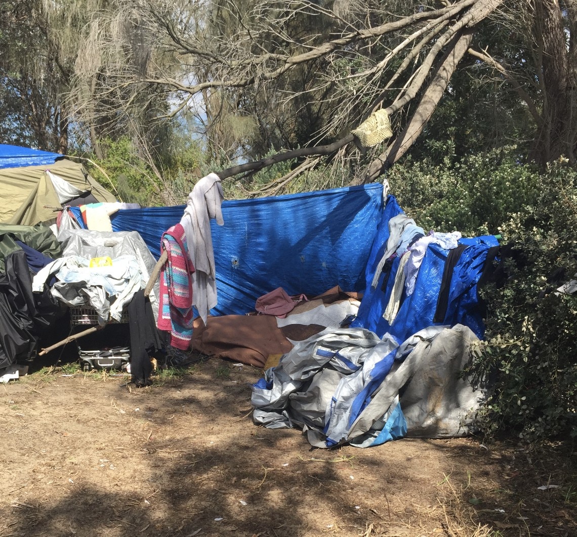 Makeshift canvas tent strung between trees