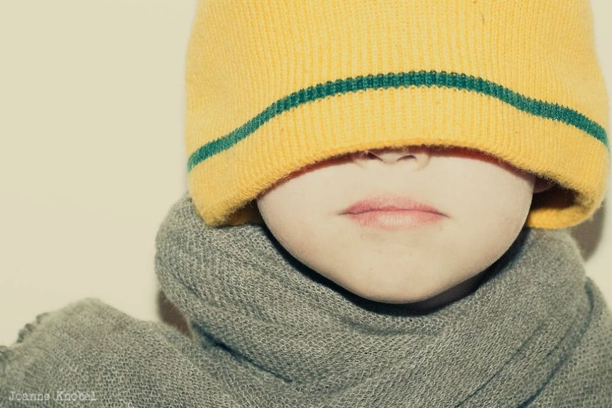 A child in an oversized beanie and scarf
