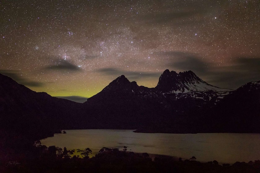 Green Aurora Australis glows behind Cradle Mountain, Tasmania.