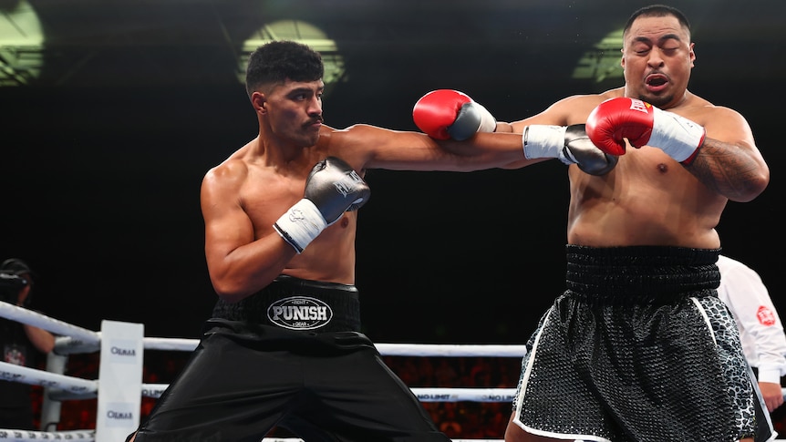 A man punches his opponent during a boxing match