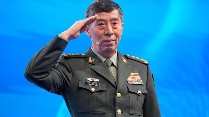 Li Shangfu salutes before delivering a speech at the Shangri-La Dialogue in Singapore