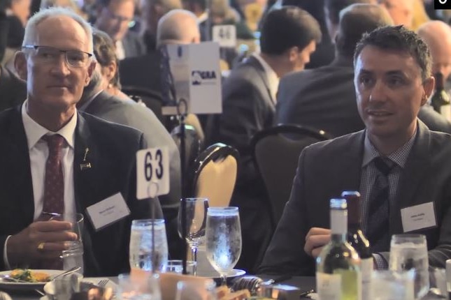 Steve Dickson (left) and James Ashby (right) seated at a table having dinner.