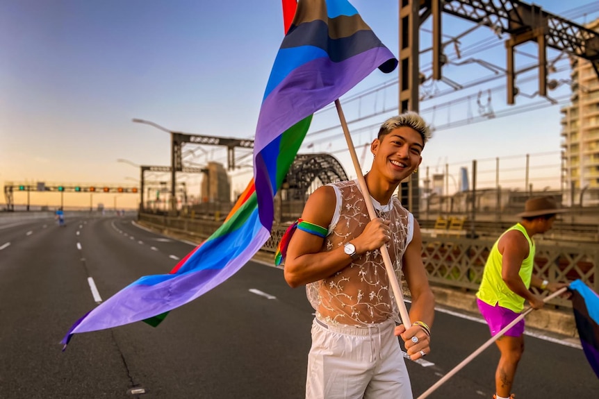 A man waves a rainbow flag on Sydney Harbour Bridge