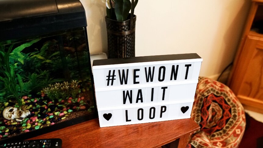 A sign in Shylie's living room reads #WeWon'tWait