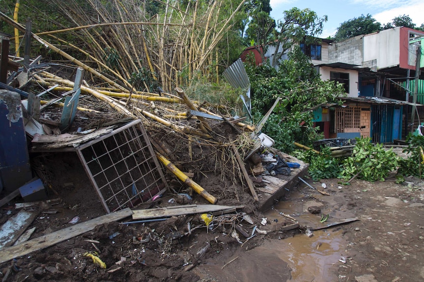 Metal and wooden debris is washed up against houses following a landslide in Costa Rica.