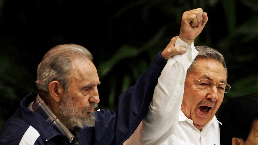 Fidel Castro raises his brother Raul Castro's hand as they sing the anthem of international socialism in 2011.