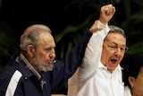 Fidel Castro raises his brother Raul Castro's hand as they sing the anthem of international socialism in 2011.