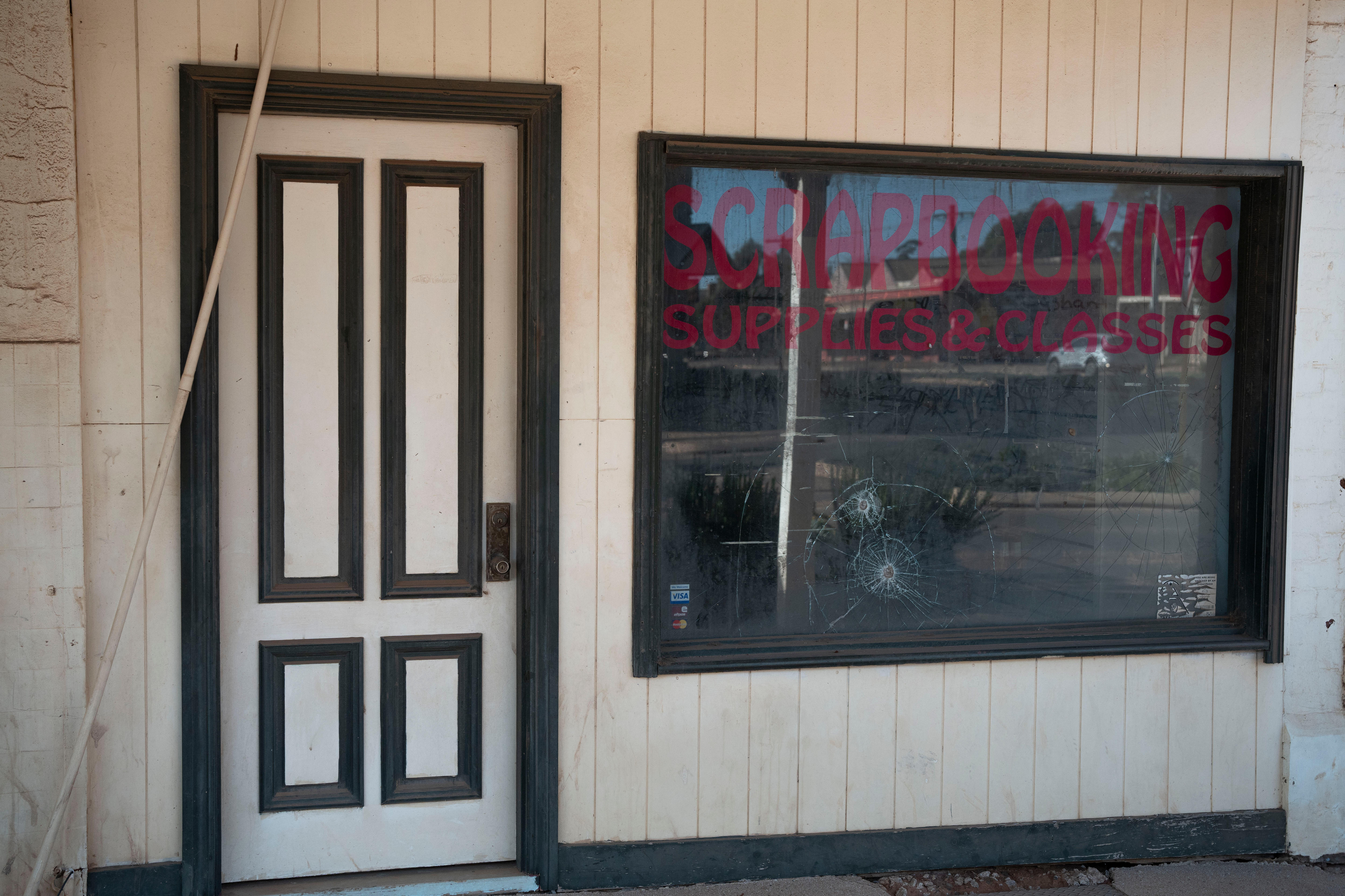 A door and Window of a shop, with the glass smashed, on Burt Street in Boulder