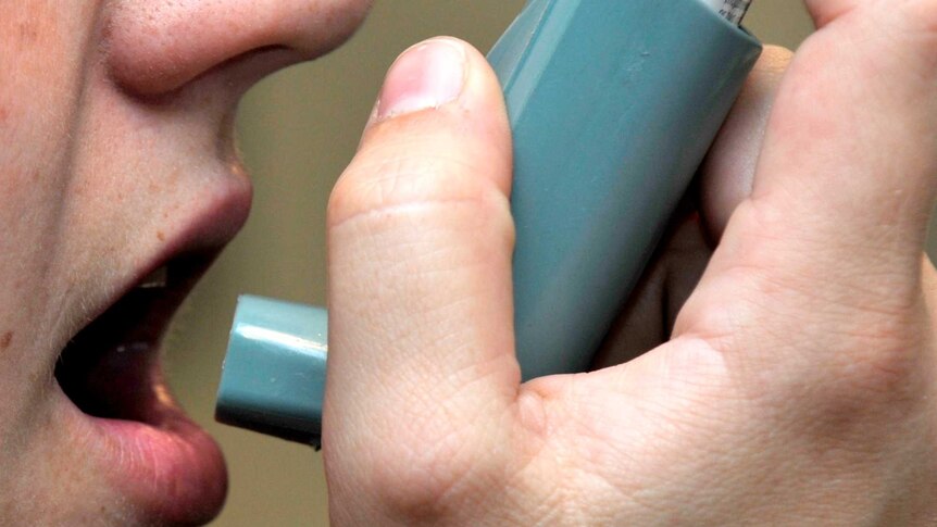Woman using an asthma inhaler