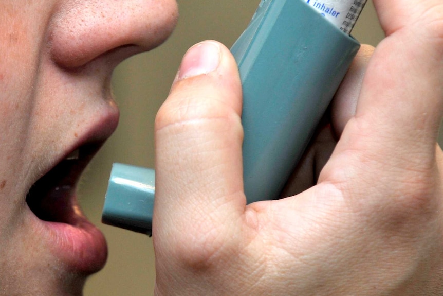 Woman using an asthma inhaler