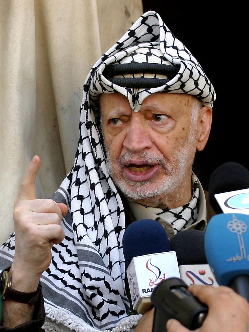 Palestinian leader Yasser Arafat talks to the press outside his office in the West Bank city of Ramallah.