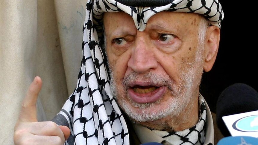 Palestinian leader Yasser Arafat talks to the press outside his office in the West Bank city of Ramallah.