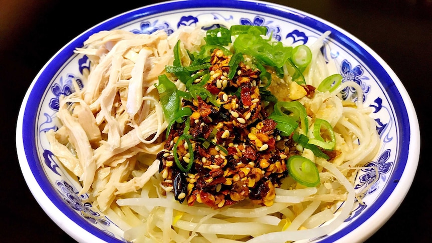 A bowl of wheat noodles with various garnishes.