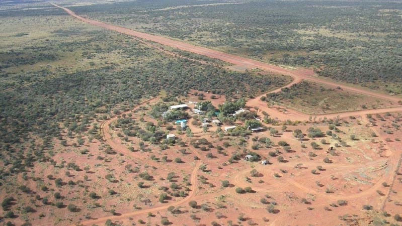 A drone photo of a roadhouse in a desert landscape.