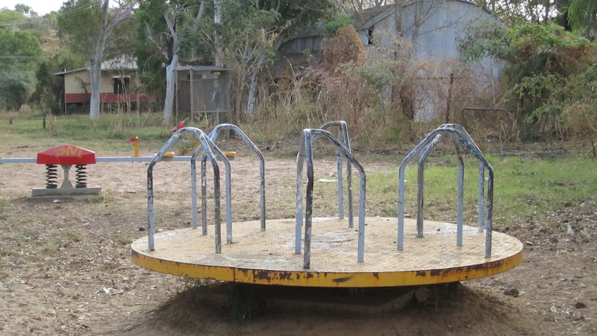 A rusty neglected piece of play equipment and a seesaw