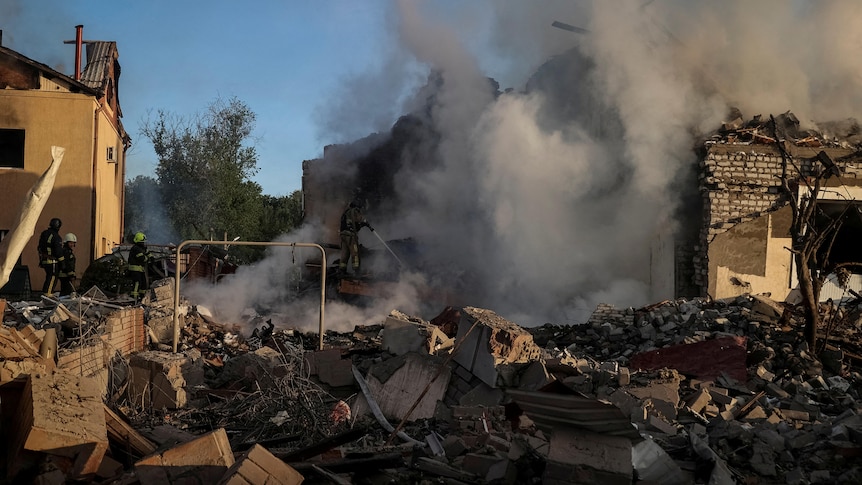 Firefighters work at a site of a Russian missile strike in Kharkiv.