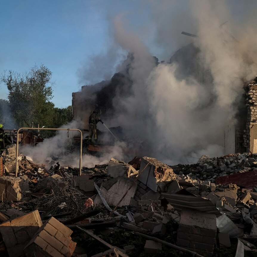 Firefighters work at a site of a Russian missile strike in Kharkiv.