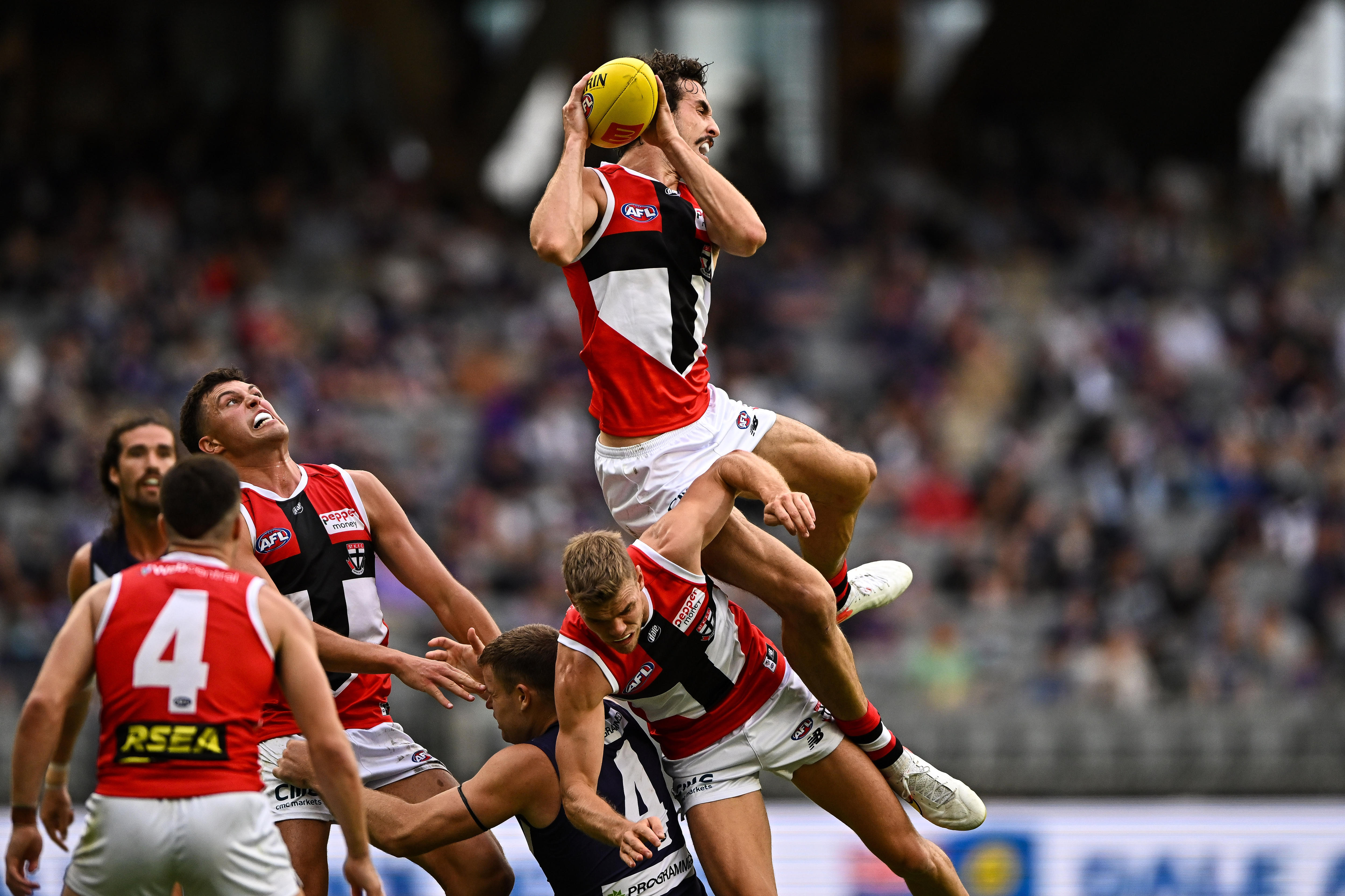 Max King holds the football while perched high atop a pack of players