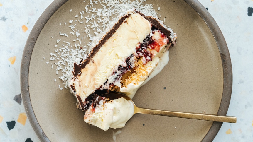 A slice of lamington ice cream cake, dusted with desiccated coconut, an easy summer dessert.