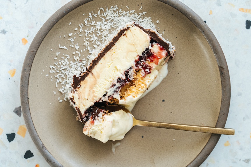 A slice of lamington ice cream cake, dusted with desiccated coconut, an easy summer dessert.