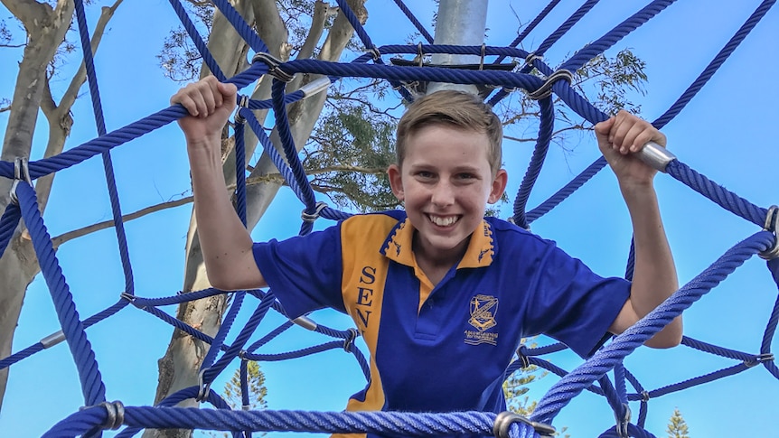 Zavier Fenwick climbs the playground equipment.