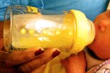 A baby drinks from a bottle
