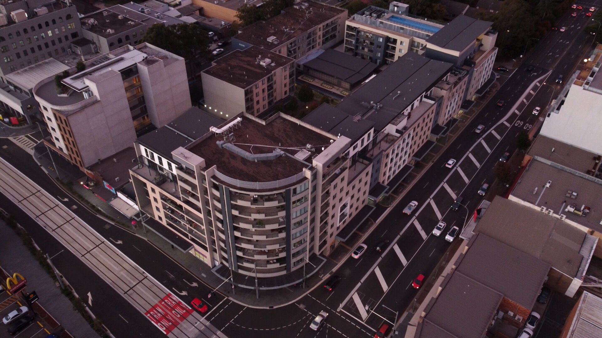 A drone photo of a large apartment and retail complex which takes up a large portion of a block.