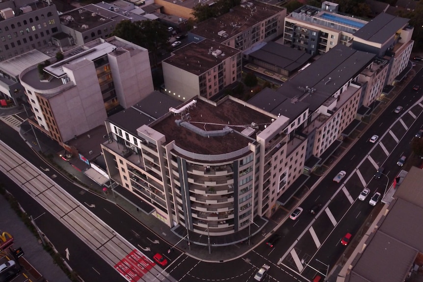 A drone photo of a large apartment and retail complex which takes up a large portion of a block.