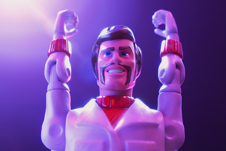 Colour close-up still of toy character Duke Caboom with both arms raised to sky in 2019 animated film Toy Story 4.