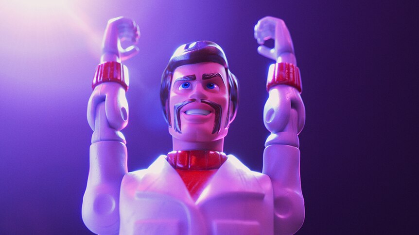 Colour close-up still of toy character Duke Caboom with both arms raised to sky in 2019 animated film Toy Story 4.