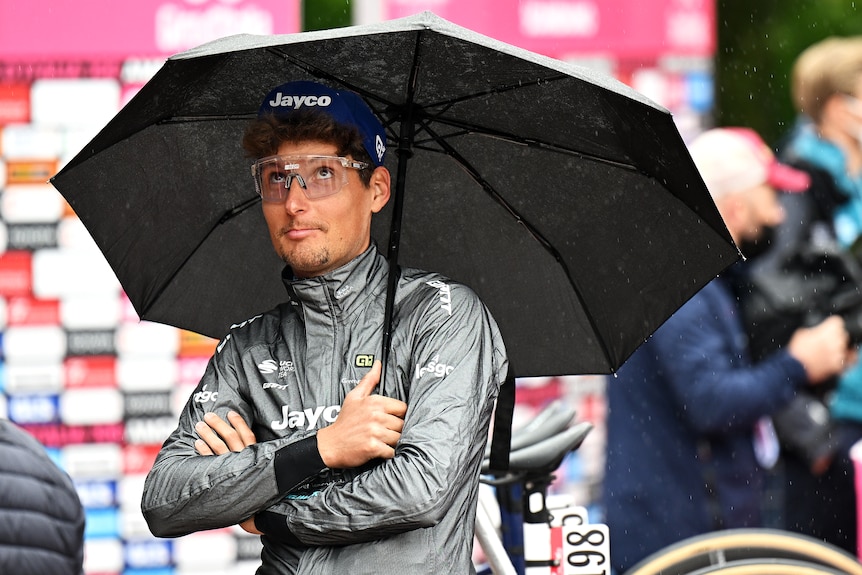 Lukas Postlberger looks under an umbrella