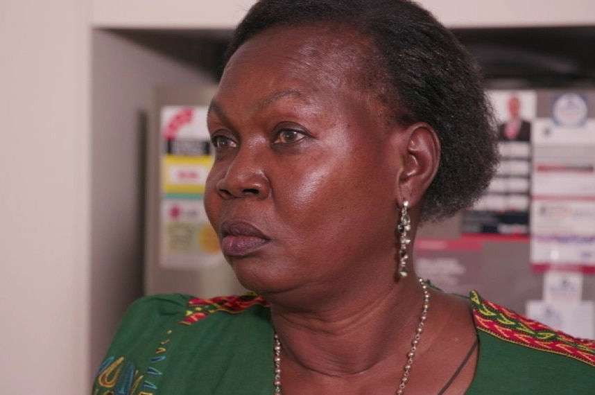 Syama Ayup stands in front of a fridge in a kitchen