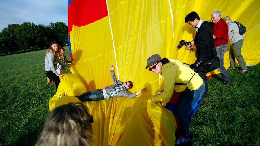 Members of the crew and customers pack the hot air balloon.