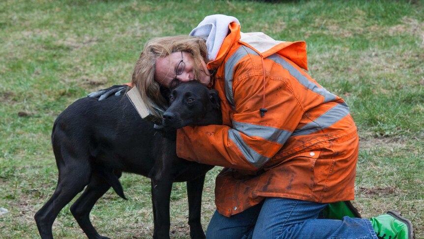 Elaine Young hugs her dog after Washington state mudslides