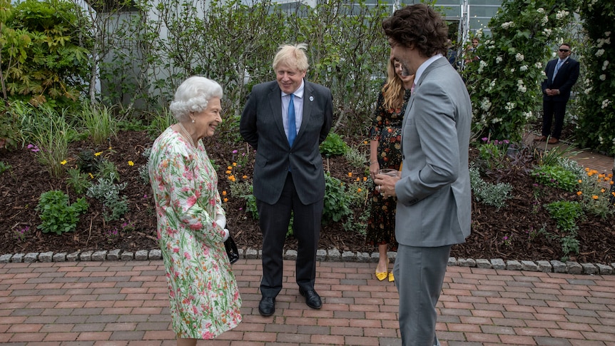 .Britain's Queen Elizabeth II, left, speaks with Prime Minister Boris Johnson and Canadian Prime Minister Justin Trudeau
