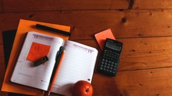 A calculator with sticky notes and an open diary planner.