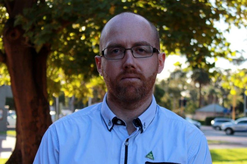 Headshot of Greens candidate for Hasluck Patrick Hyslop standing in a park.