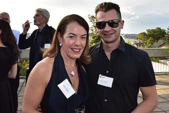 a man and a woman both wearing name tags standing outdoors and smiling at the camera