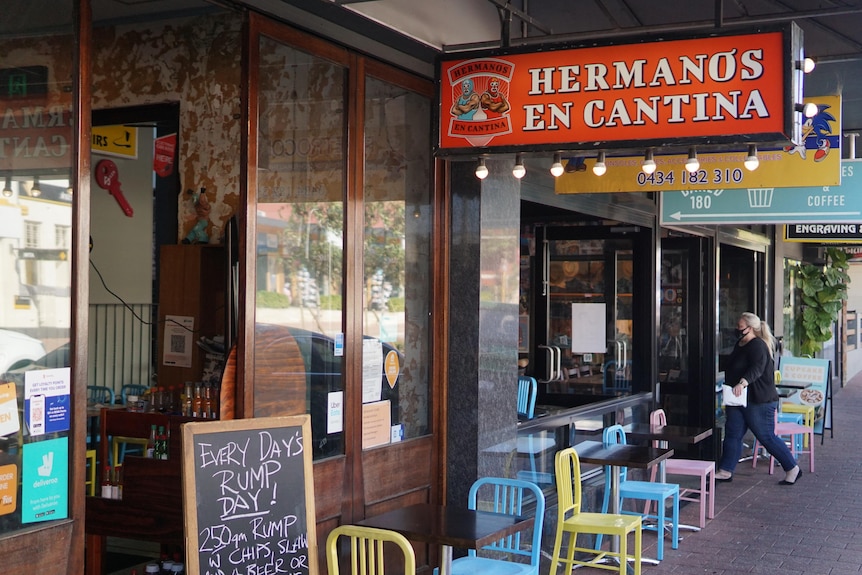 Brightly coloured chairs and posters adorn the outside of the restaurant.