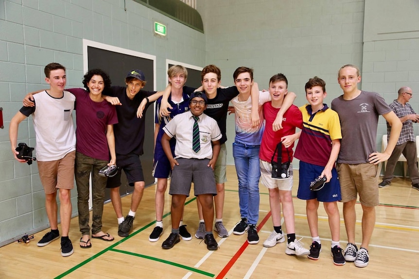 A group of teens smiling and linking arms